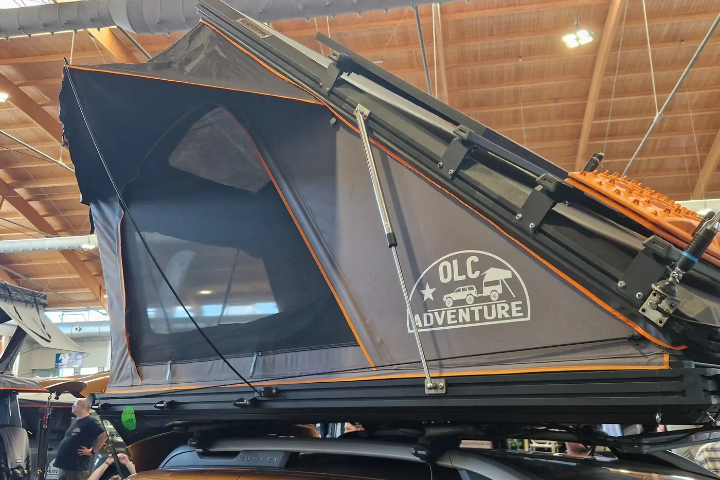 OLC Adventure Aluminium-Keilzelt aufgeklappt auf einem Pickup, graue Schale mit orangen Reissverschluessen
